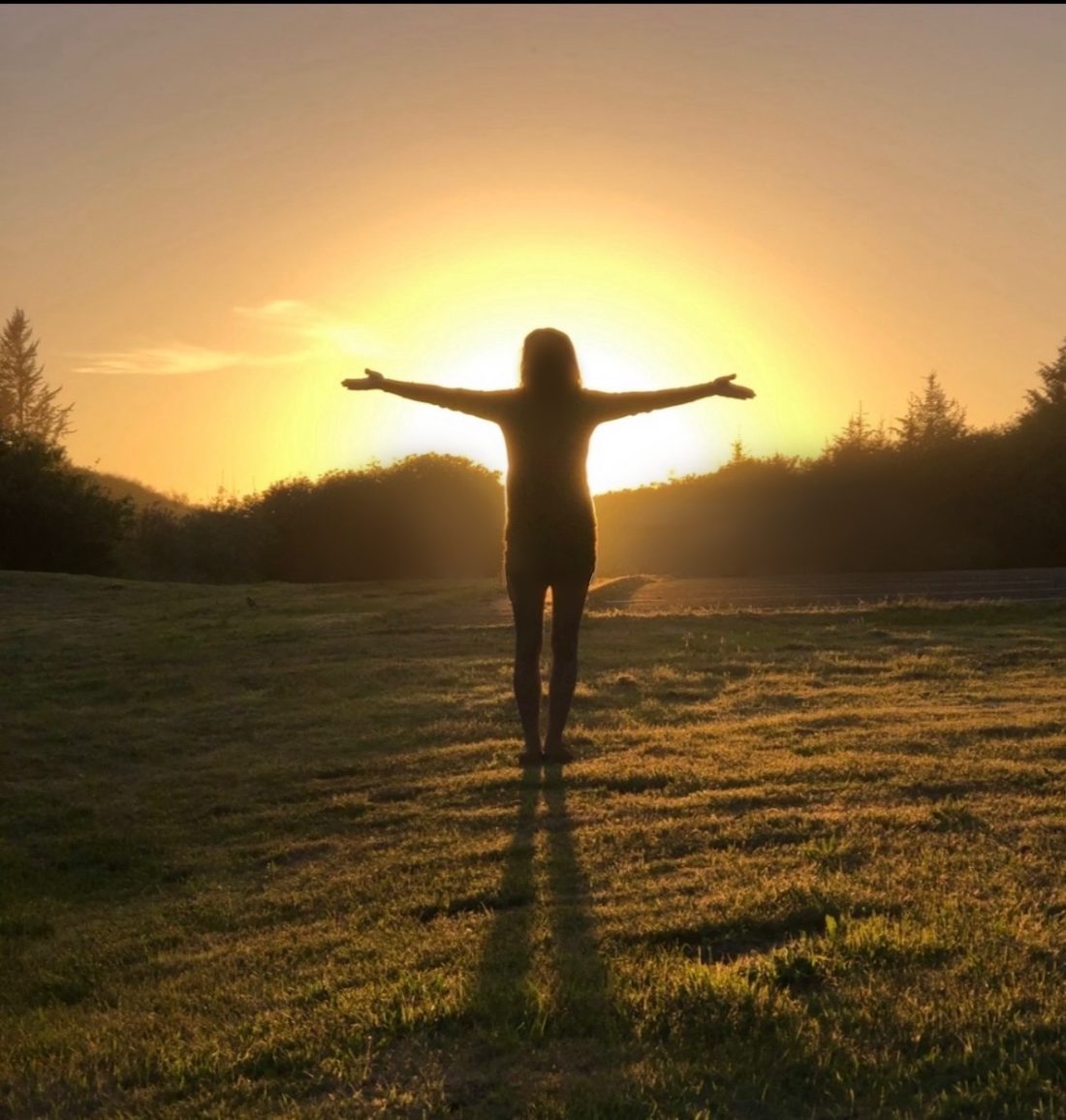 Standing in the morning light, arms open